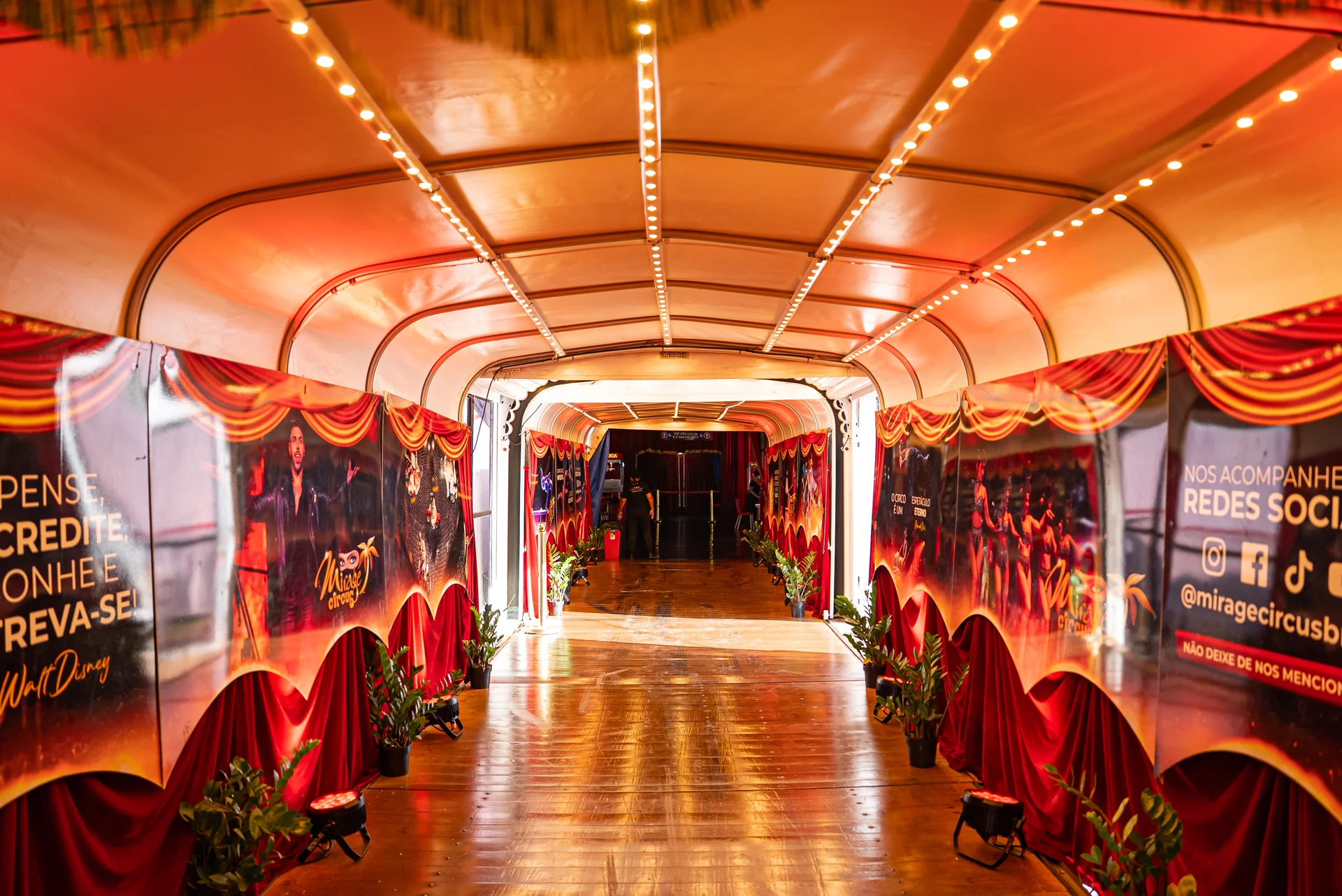 Corredor de entrada iluminado com banners do Mirage Circus