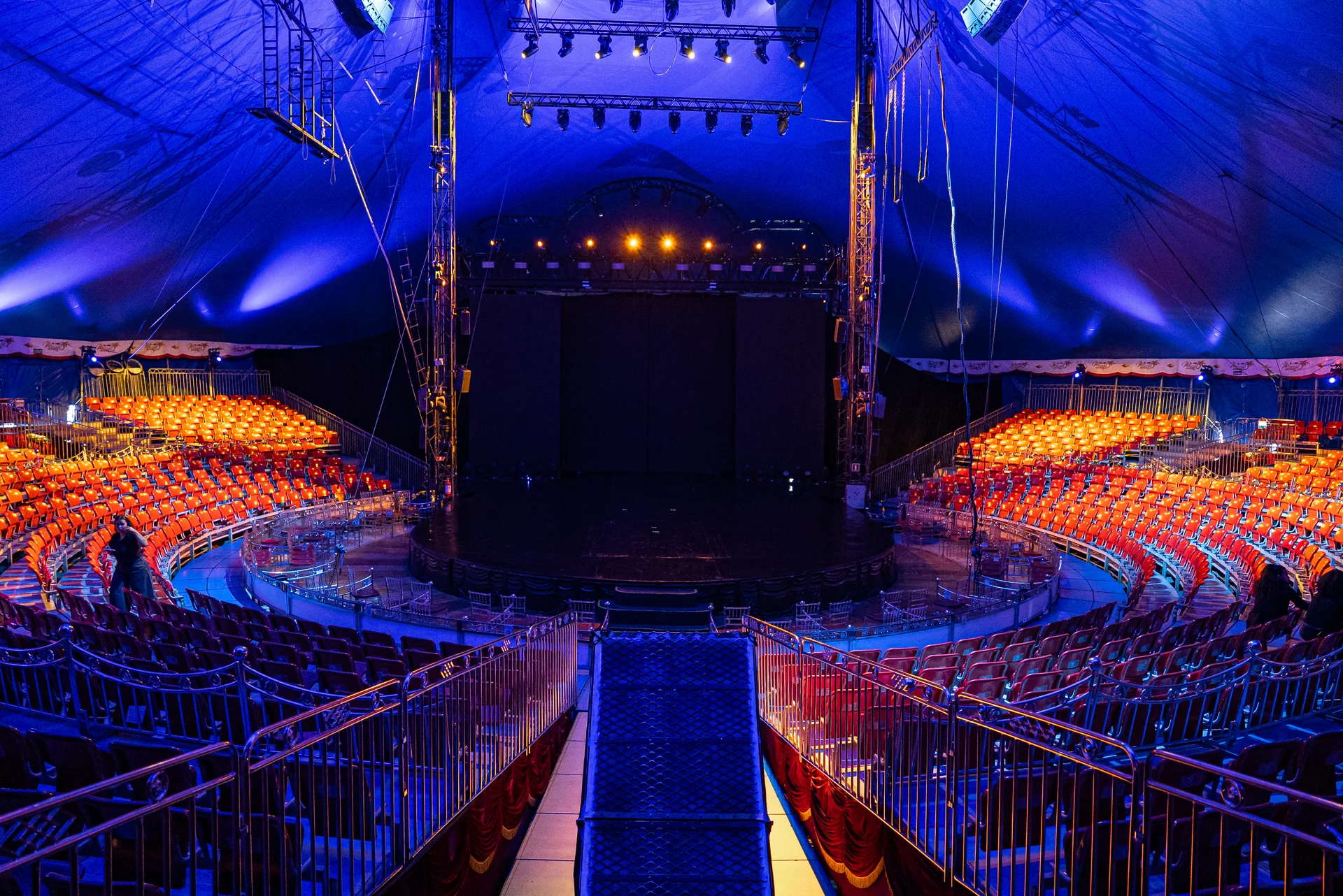 Interior da tenda com palco circular e arquibancada